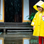 키즈용 레인코트 브랜드 - **

A young Vietnamese girl (age 6-8) wearing a bright yellow poncho-style raincoat with a cute cart...